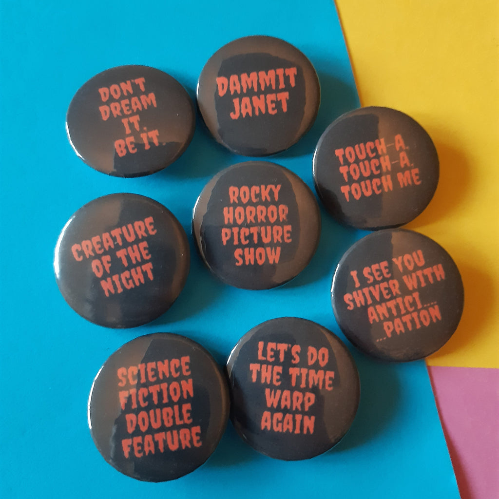 Seven round pin-back buttons with dark black backgrounds and red text displaying movie and TV show quotes, arranged on a colourful background split diagonally between bright blue and yellow with a small pink corner.