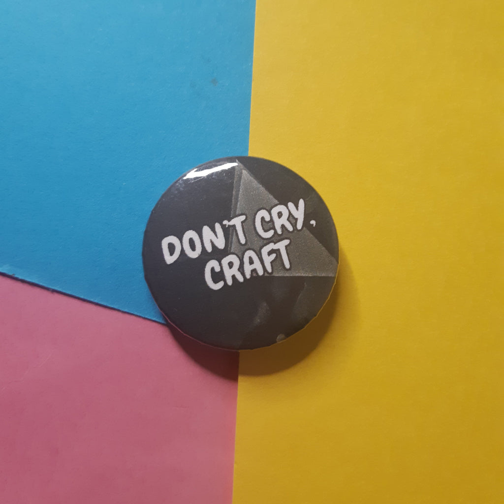 A round pin badge with the text 'DON'T CRY. CRAFT.