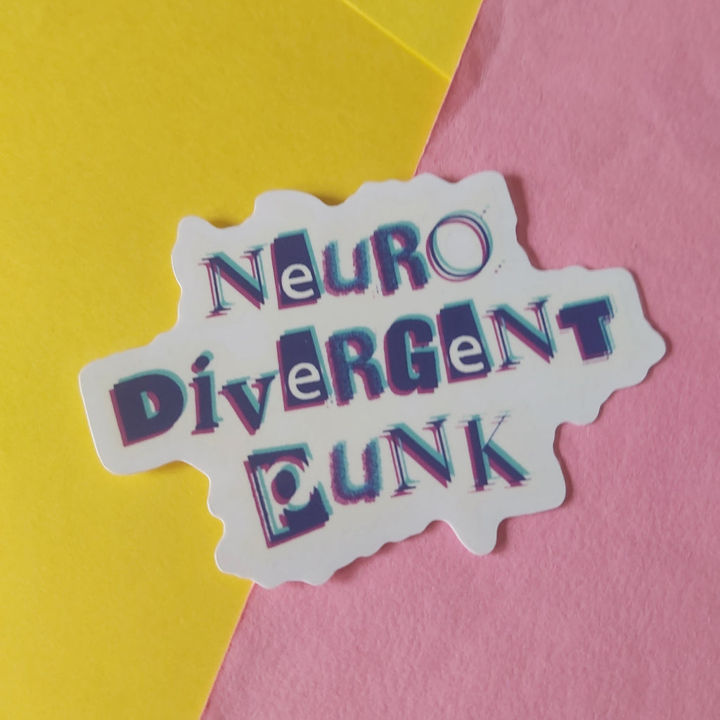 A die-cut sticker with the words 'Neuro Divergent Punk' in stylised 3D lettering, placed on a background split diagonally between yellow and pink paper.