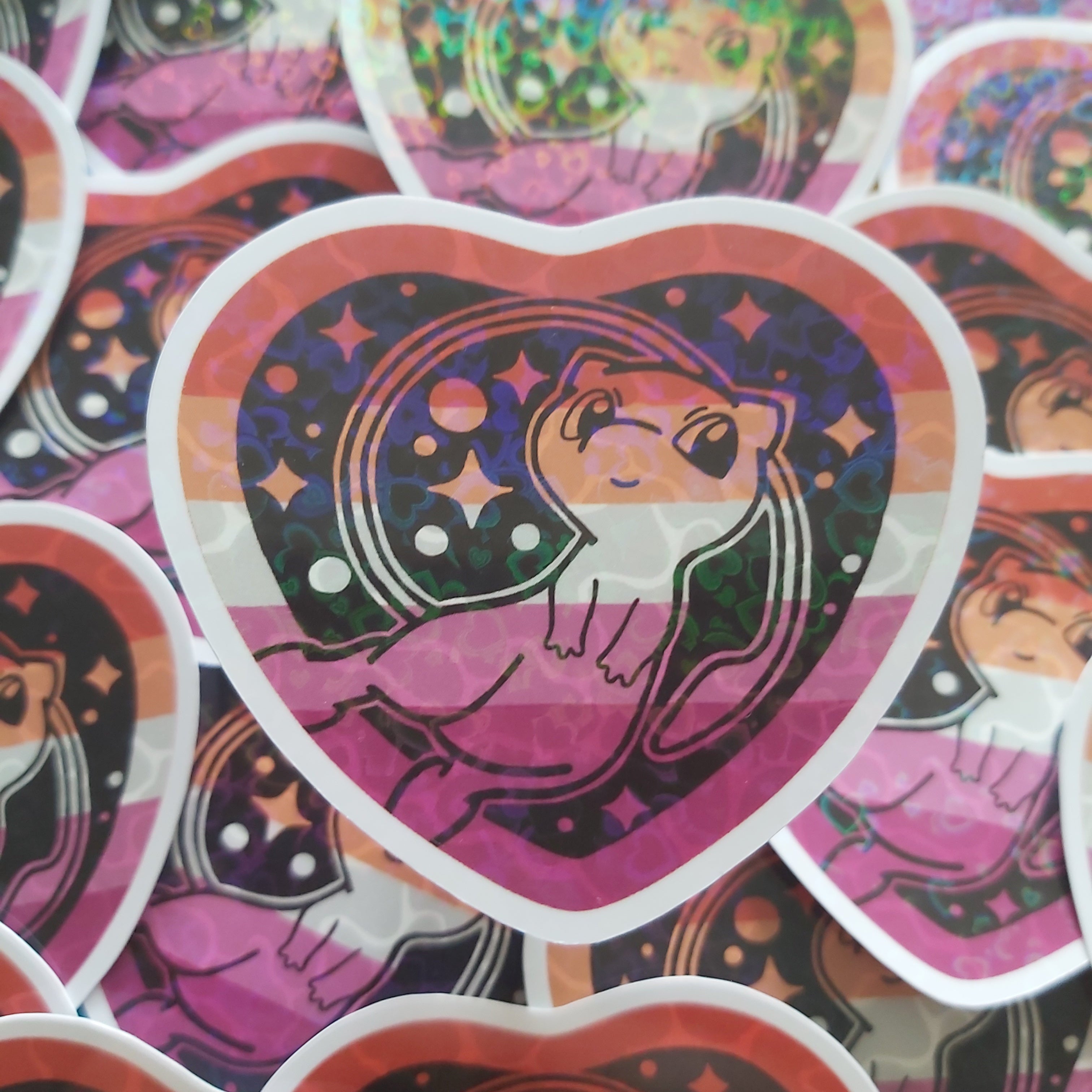 A heart-shaped sticker featuring a pokemon character against a pink, purple, and black patterned background, surrounded by other overlapping heart-shaped stickers.