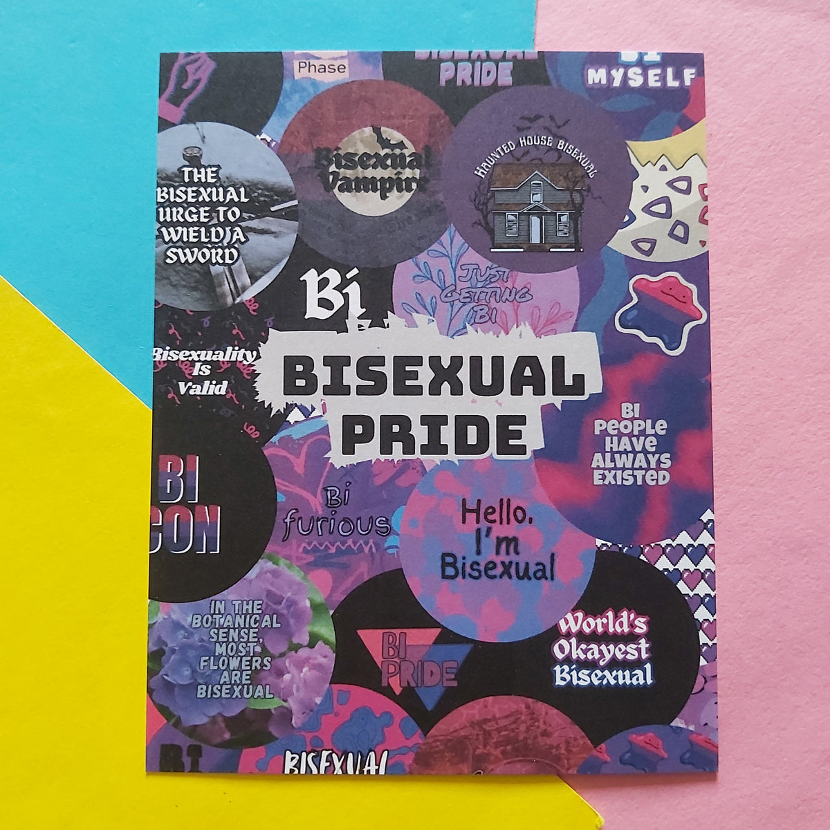 An art print with a colourful bisexual pride collage design, featuring text like 'Bisexual Pride' and 'Hello, I'm Bisexual,' styled on a split pink and blue background.