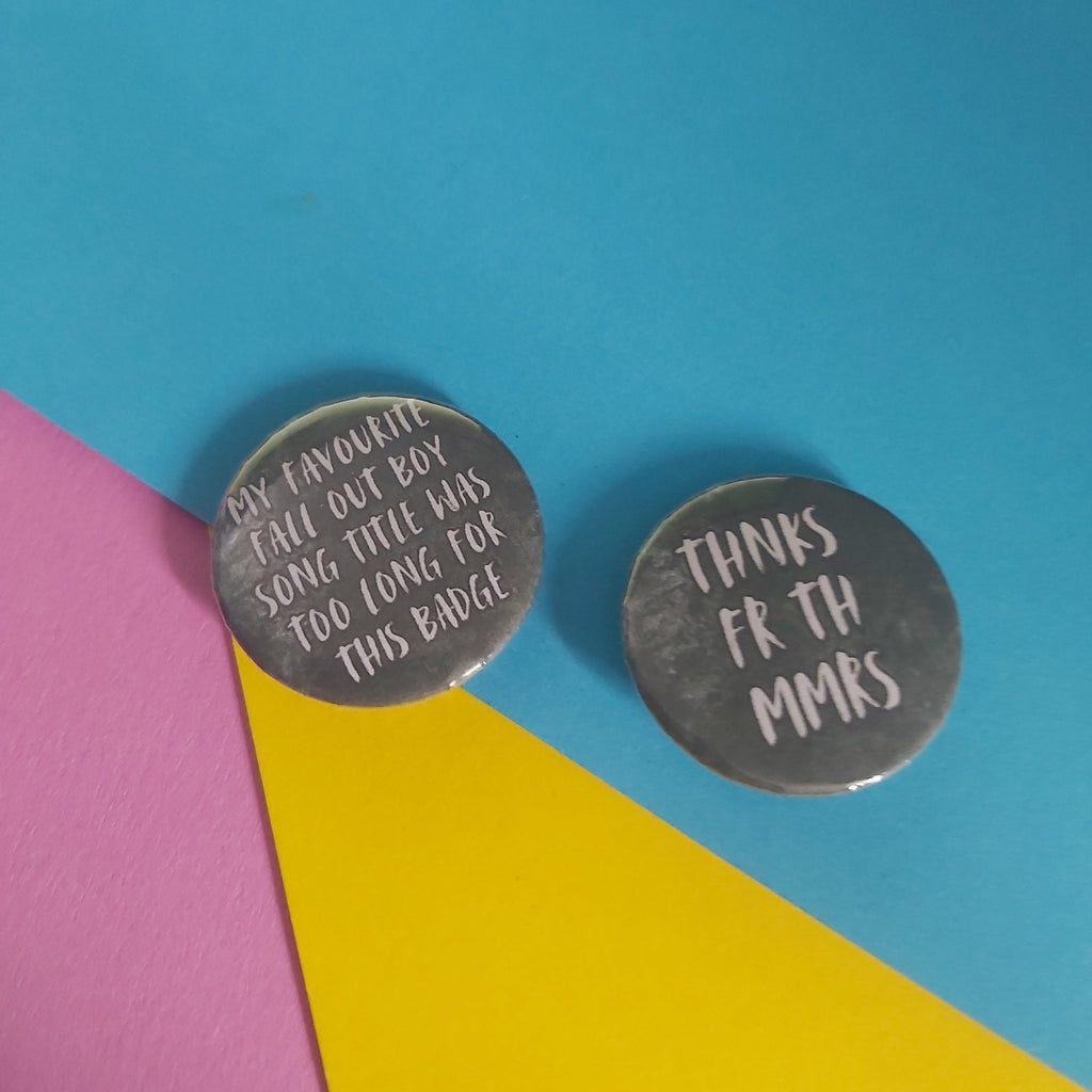 Two round emo-themed badges with text, displayed on a colourful background split diagonally into pink, yellow, and blue sections.