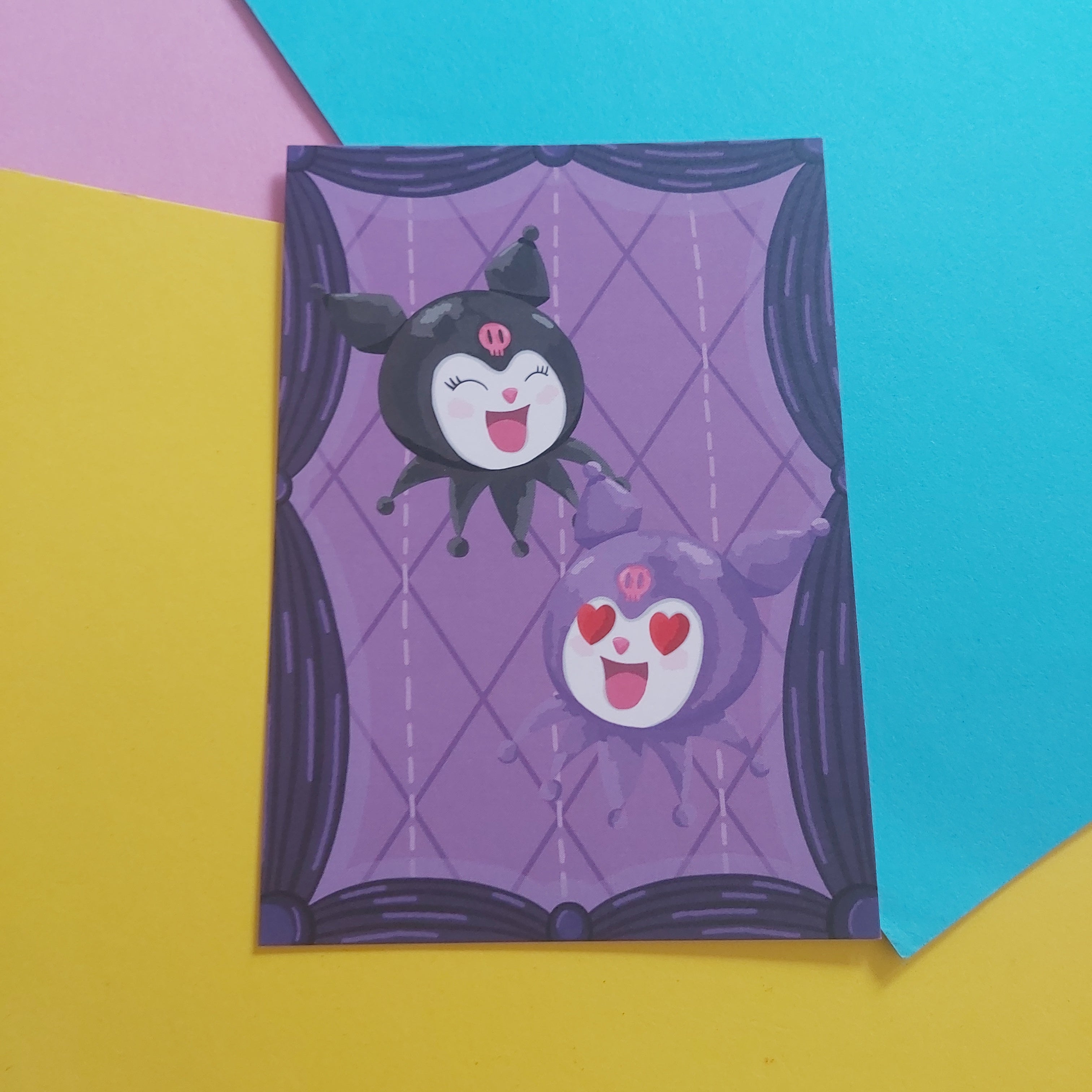An art print featuring two cute cartoon characters, Kuromi, displayed on a colourful background of yellow, pink, and blue paper.