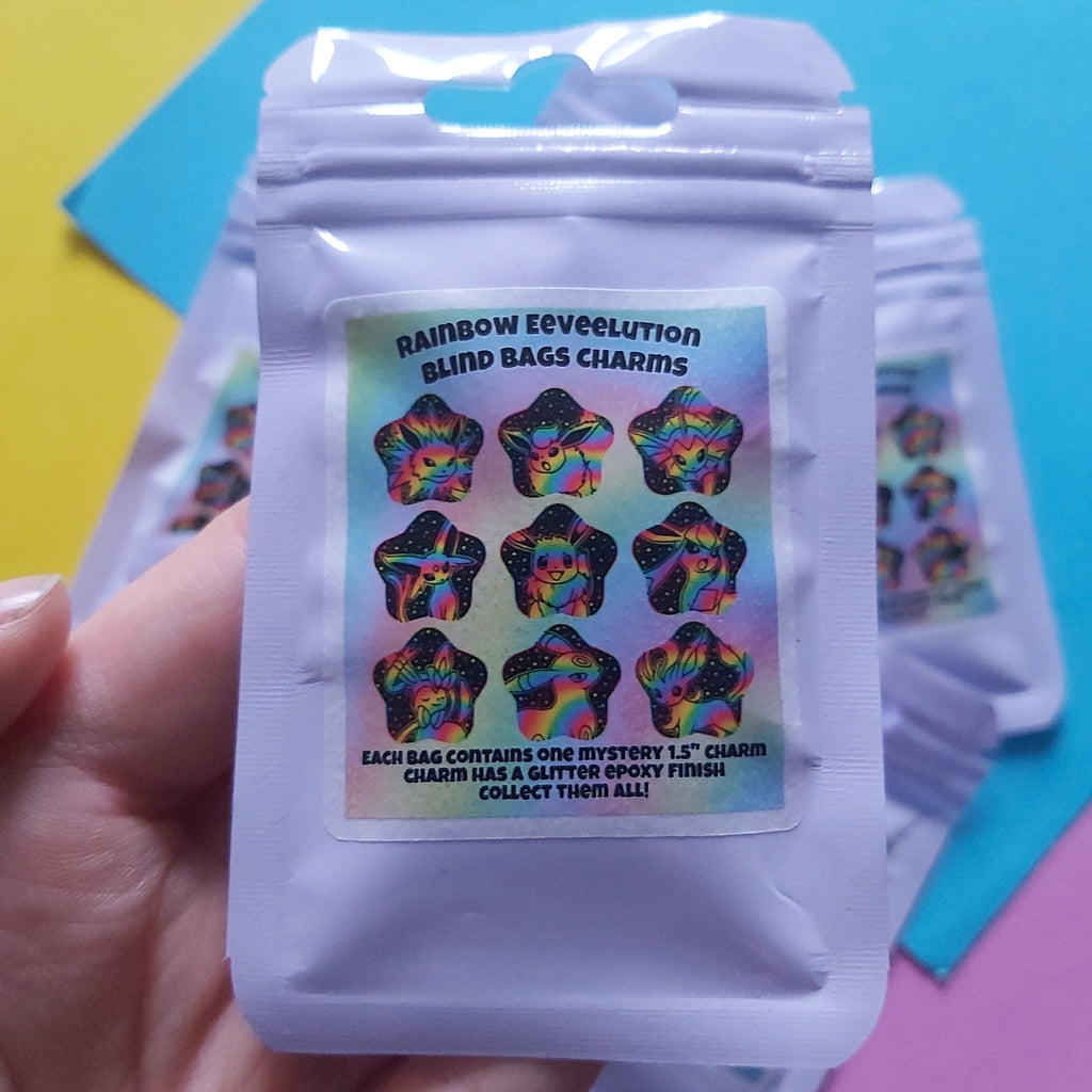 A hand holding a purple resealable pouch labelled 'Rainbow Eeveelution Blind Bags Charms,' with several matching pouches stacked behind it on a bright pastel background.