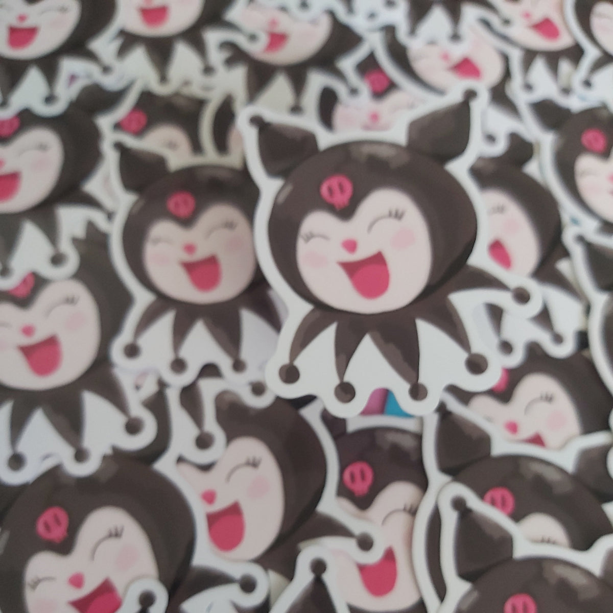 A dense pile of cartoon character stickers featuring a black-haired character with a pink bow and a wide open smile, shown close up.