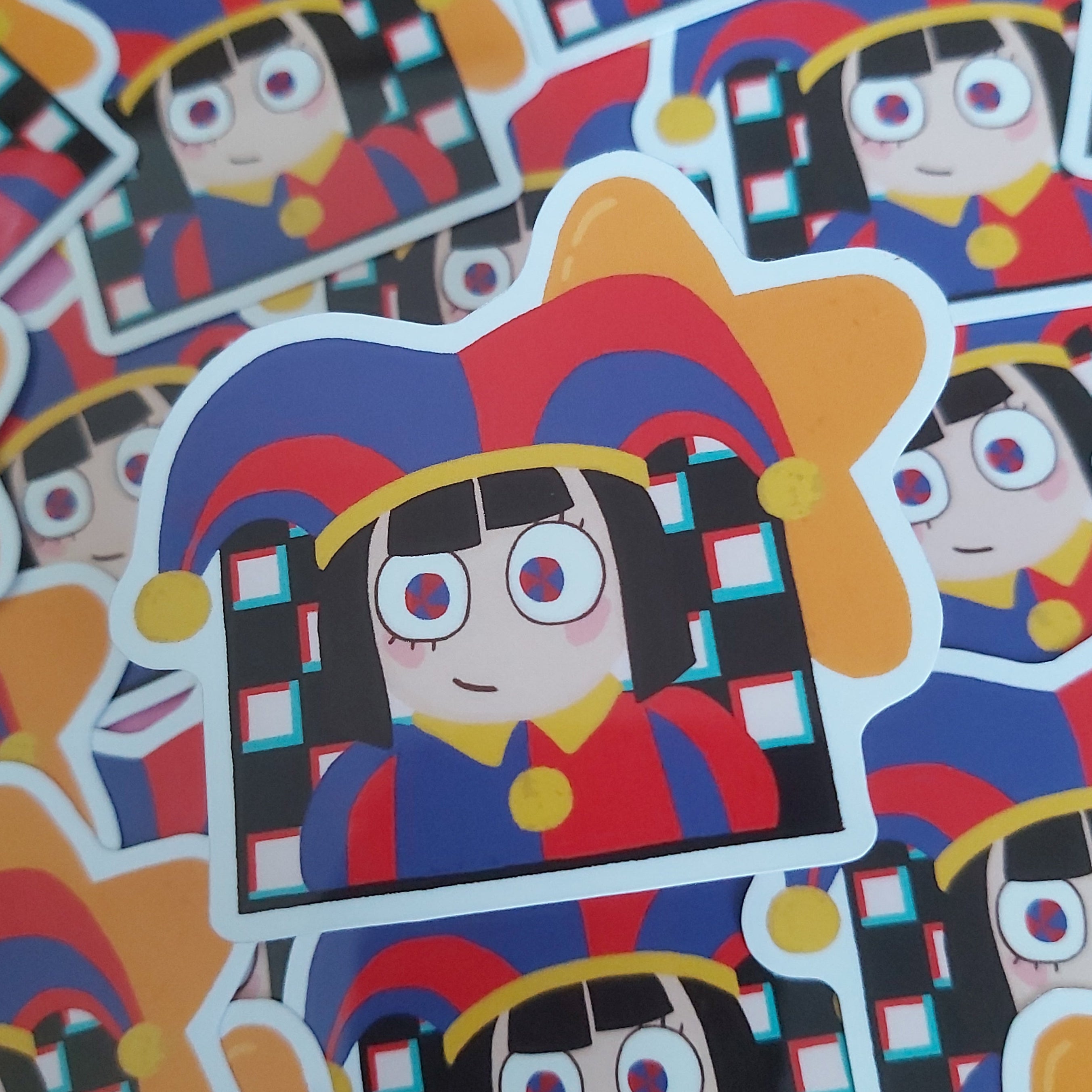 A close-up pile of colourful character stickers featuring a stylised anime girl in a red, blue, and yellow jester hat