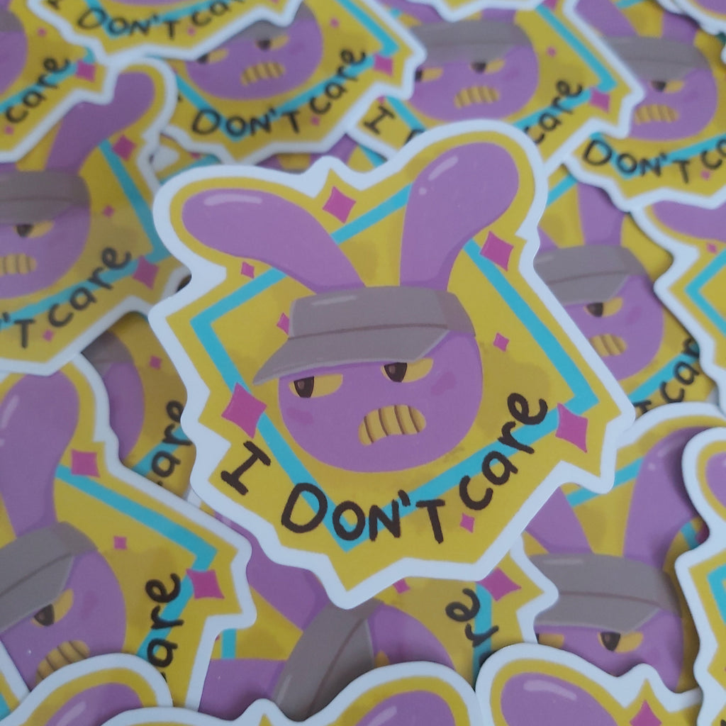 A close-up of multiple die-cut stickers featuring a purple bunny wearing a grey hat with the text 'I DON'T CARE' with a yellow and blue outline