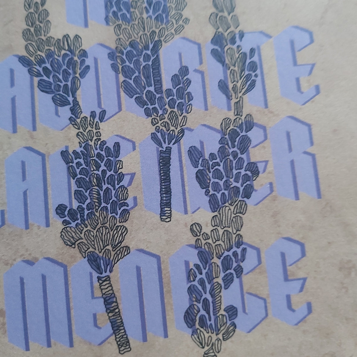 A close-up of a printed design featuring lavender flower illustrations layered over large purple text on a textured beige background.