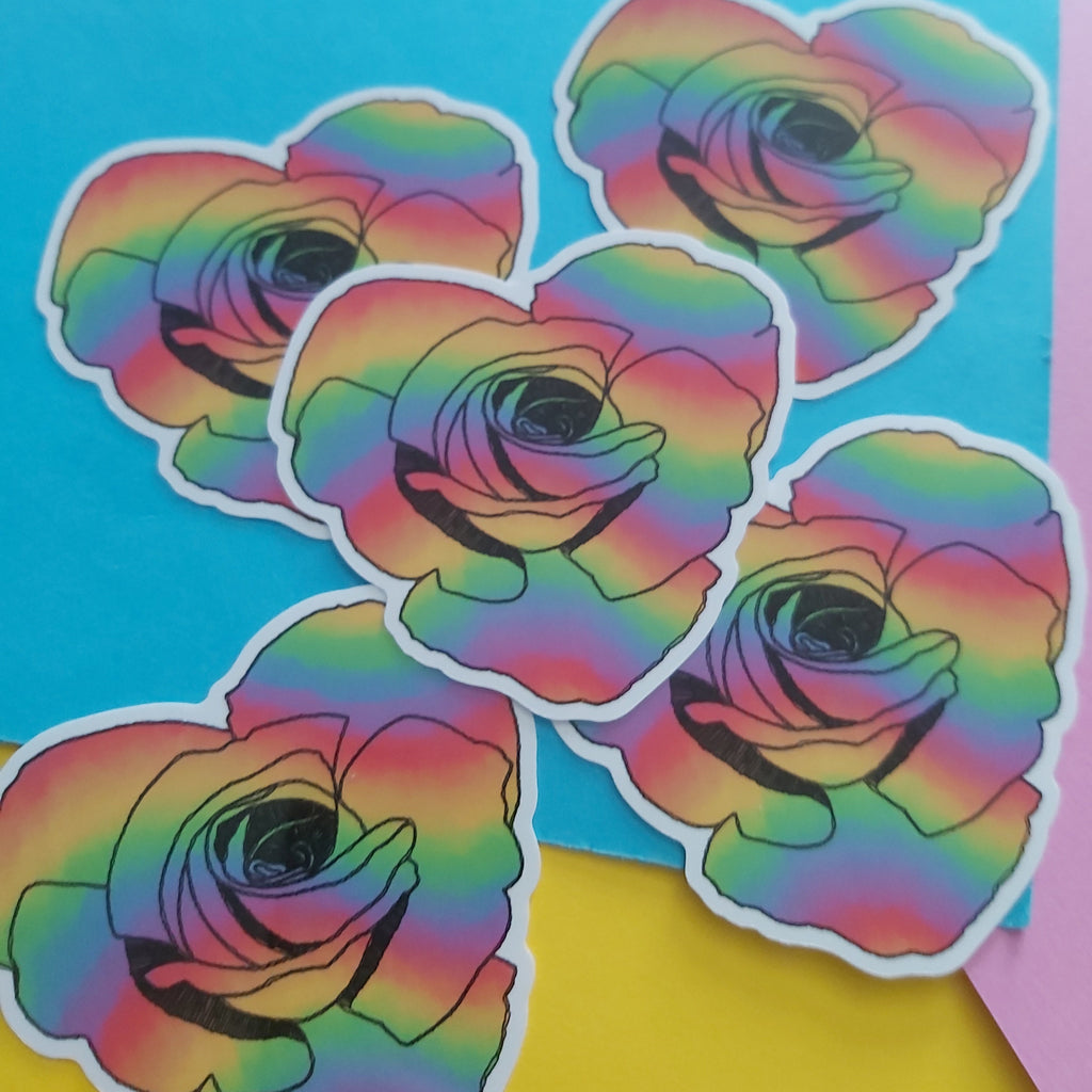 Five die-cut stickers featuring rainbow-colored roses with black outlines, arranged on a bright blue background with yellow and pink paper accents.