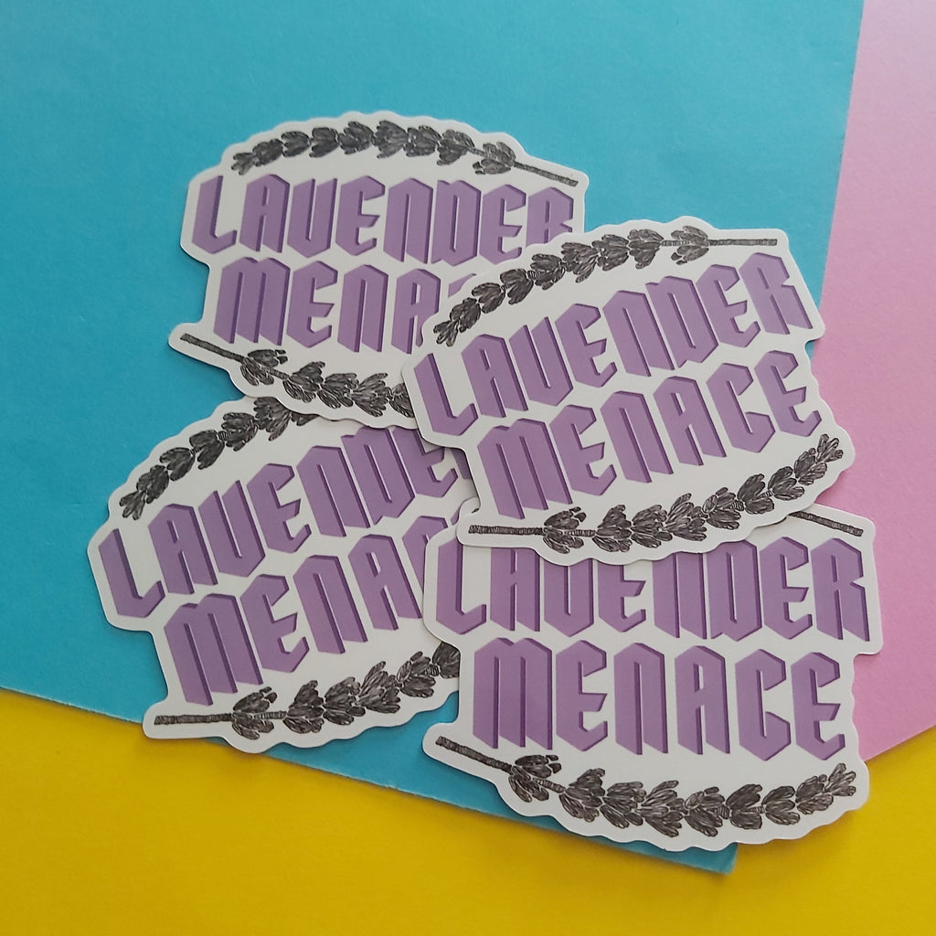 Four die-cut stickers featuring the phrase 'LAVENDER MENACE' in purple retro-style lettering with a black floral border, arranged on a colourful background of blue, pink, and yellow paper.