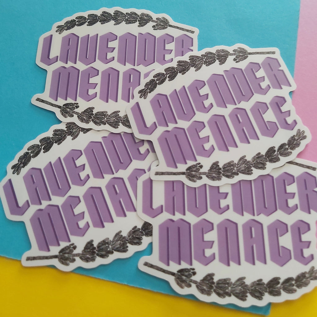 Four die-cut stickers featuring the words 'LAVENDER MENACE' in purple block letters with a black lavender wreath border, arranged on a bright blue background with yellow and pink sections visible at the edges.