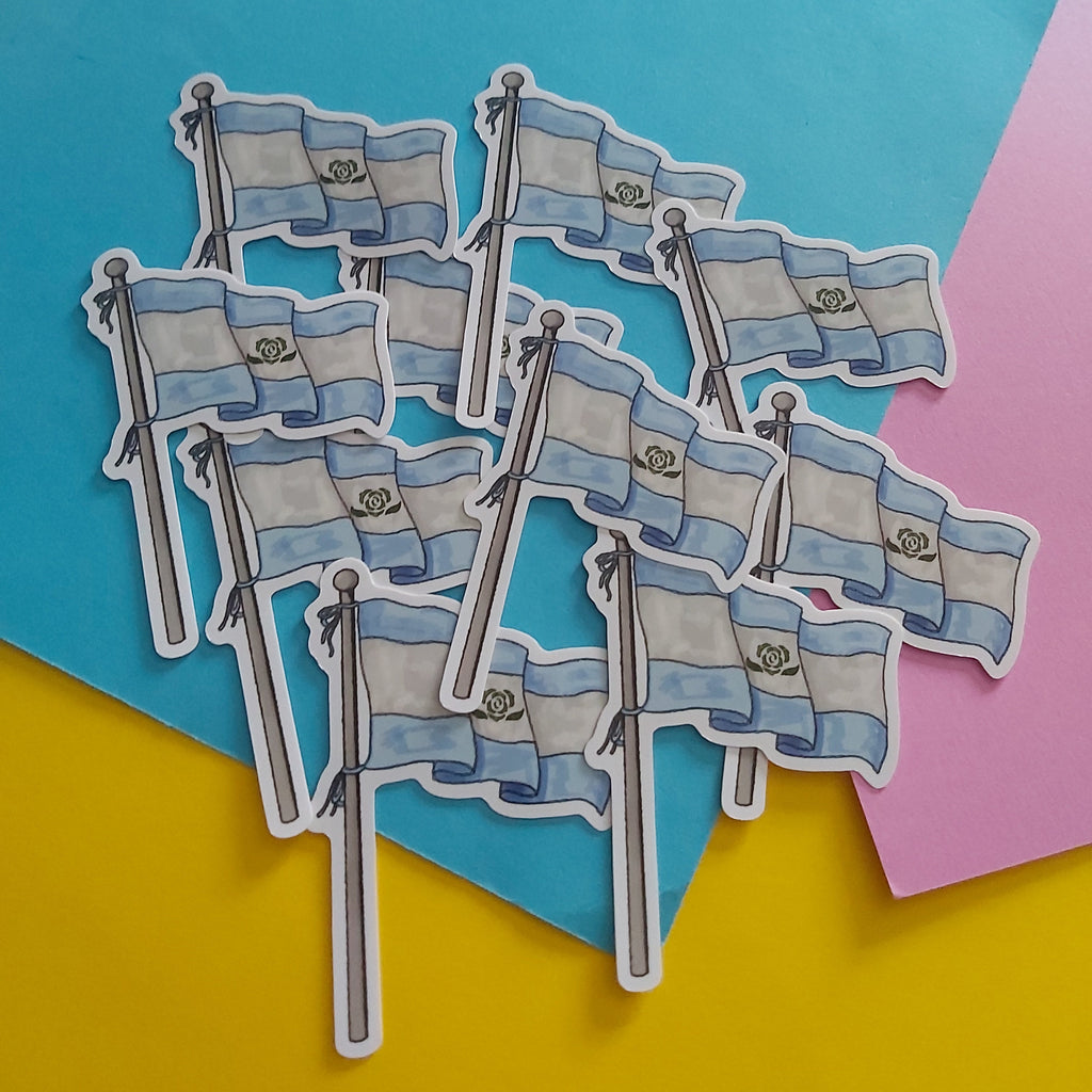 A set of die-cut stickers depicting the Achillean flag, arranged on a colourful background of yellow, blue, and pink paper.
