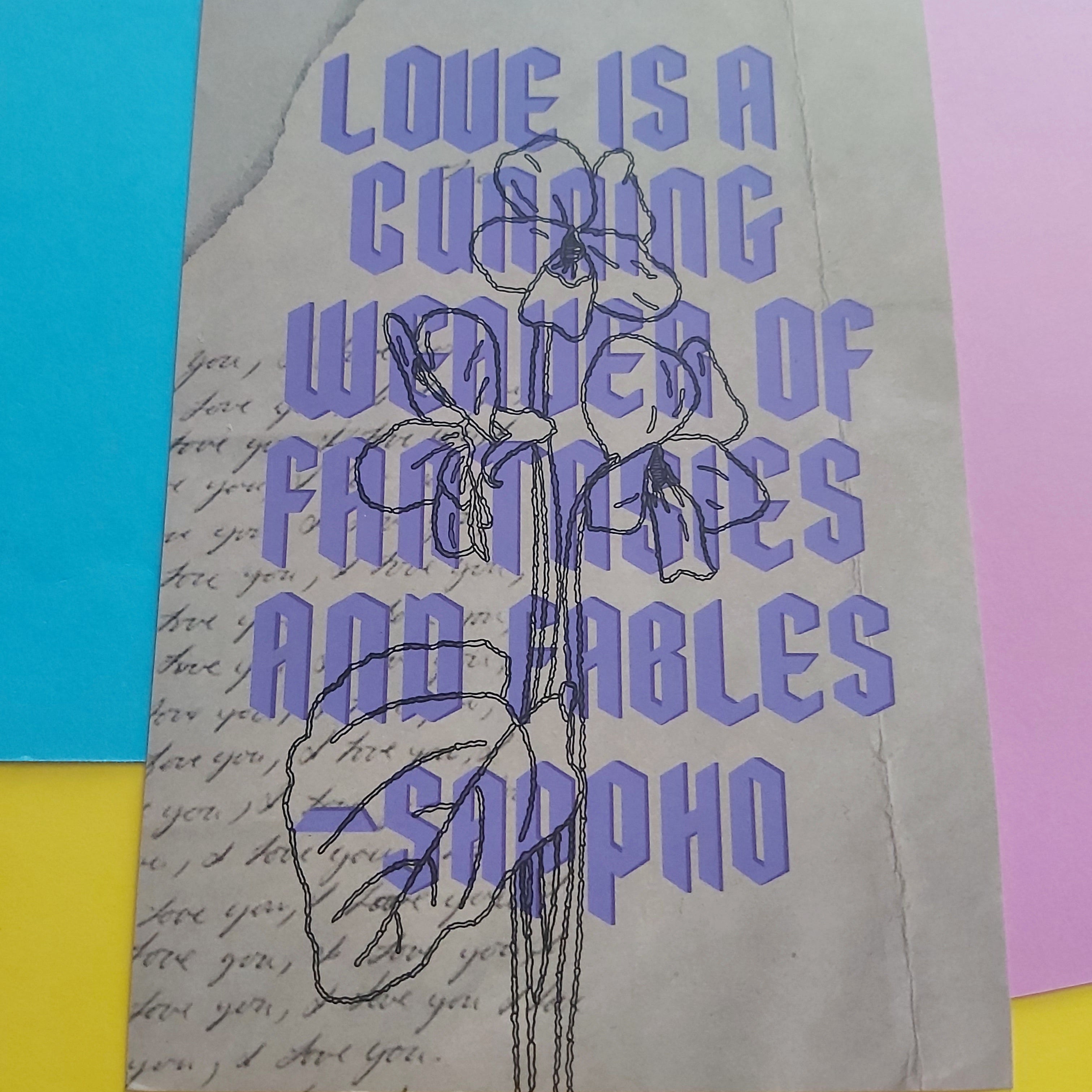 An art print featuring a quote by Sappho in purple text over a textured beige background with script handwriting and a black line drawing, displayed on a colourful background of blue, pink, and yellow paper.