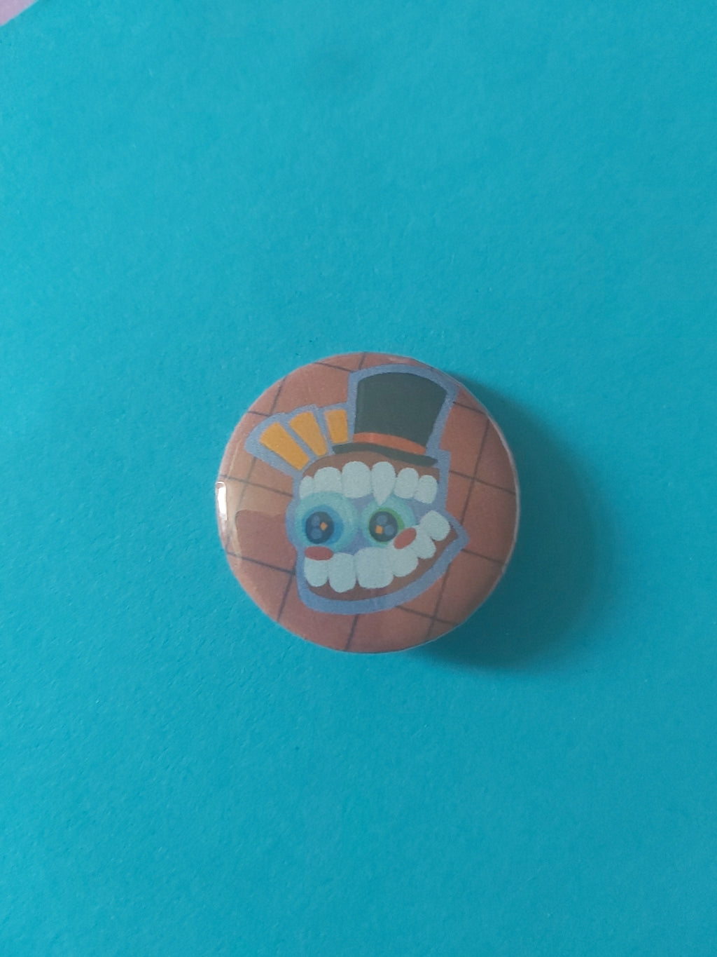 A round pinback button featuring a cartoon character with a top hat, set against a red background.