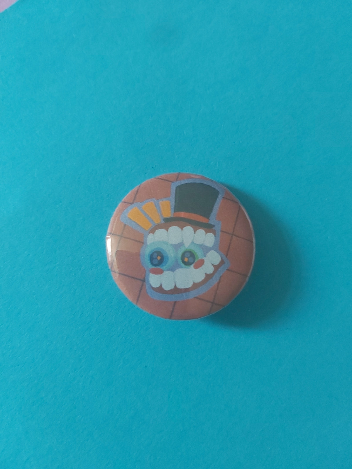 A round pinback button featuring a cartoon character with a top hat, set against a red background.