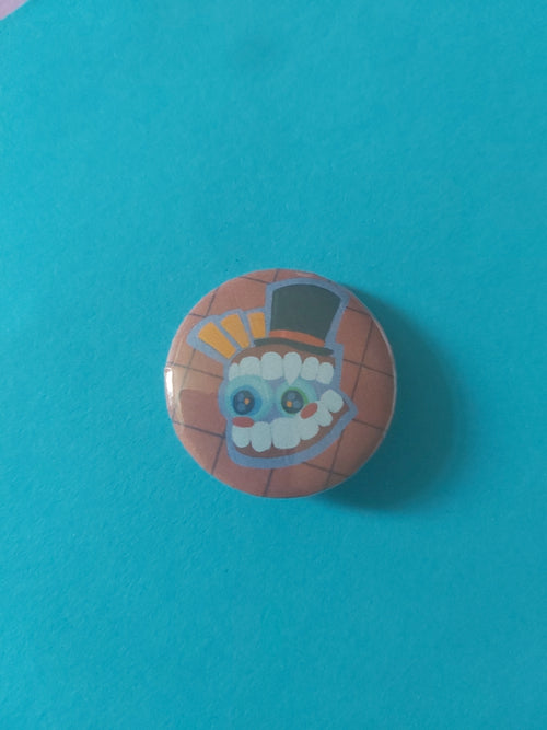 A round pinback button featuring a cartoon character with a top hat, set against a red background.