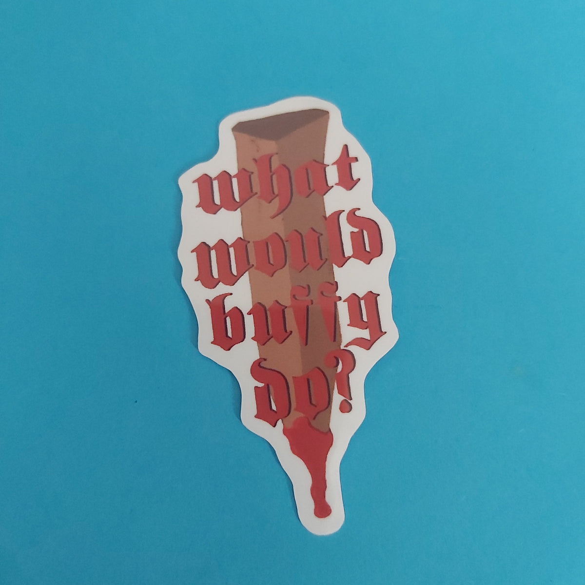 A die-cut sticker featuring a brown wooden stake with red Gothic-style text reading 'what would buffy do?' and dripping red blood, shown on a solid blue background.