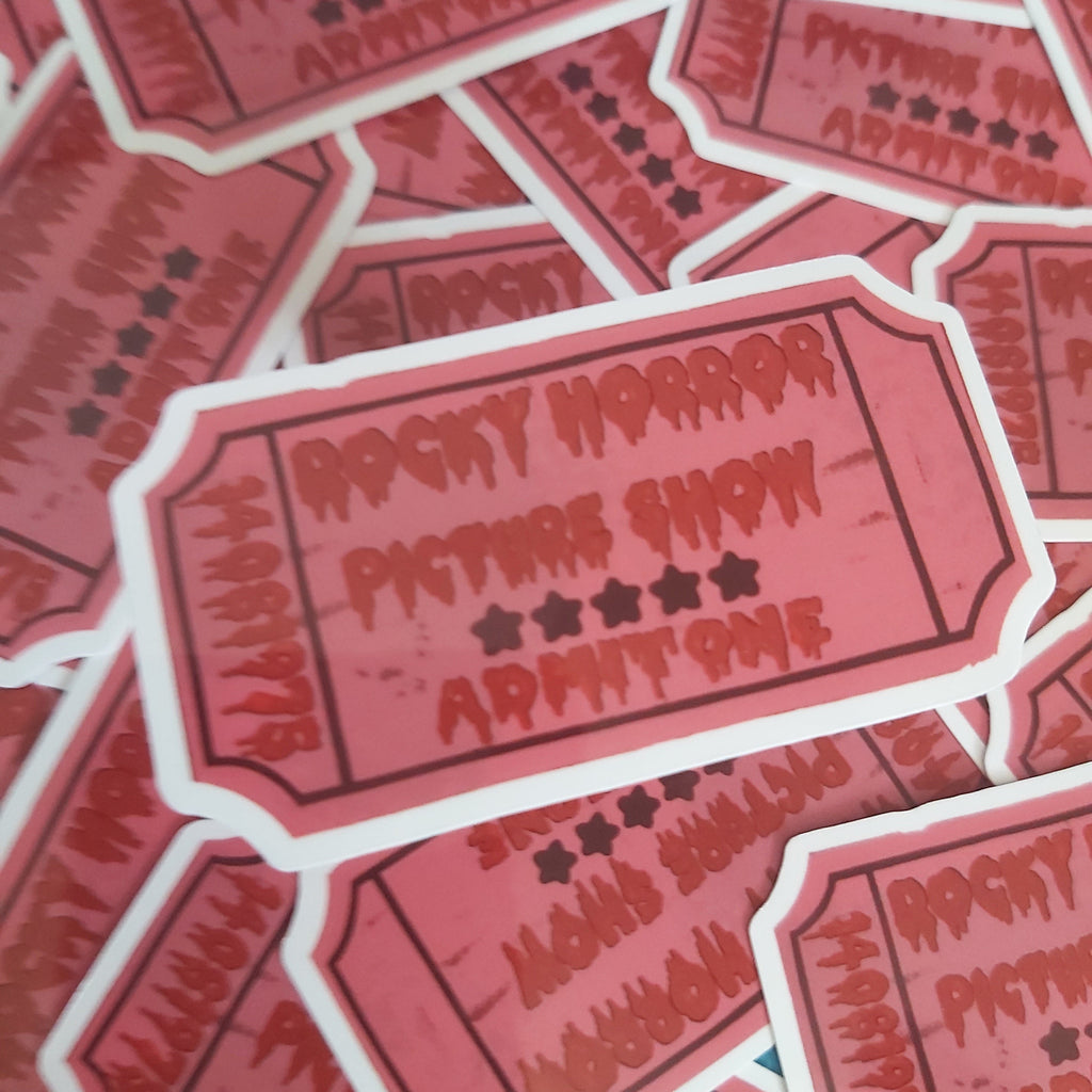 A pile of die-cut stickers shaped like vintage red-and-white movie ticket stubs, printed with the text 'Rocky Horror Picture Show Admit One' and star ratings.
