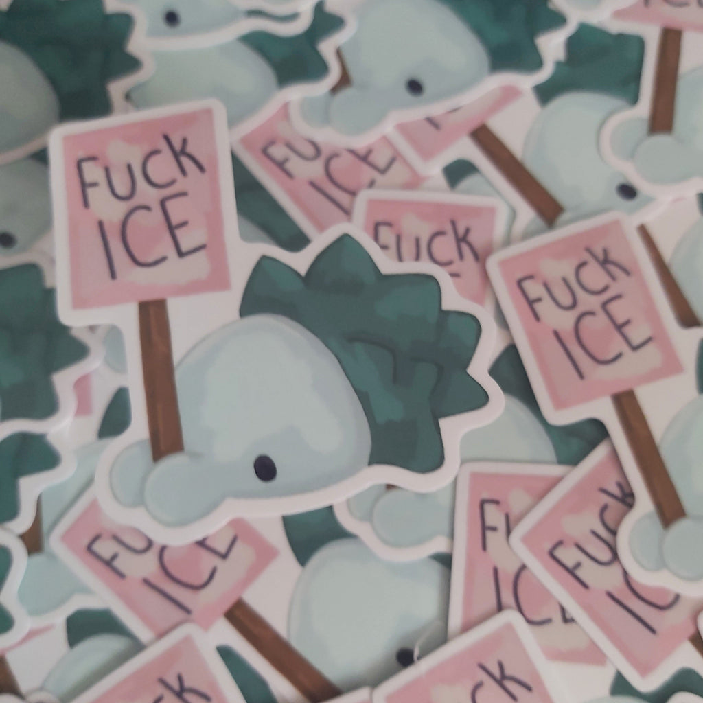 A pile of die-cut stickers featuring a pokemon holding a pink sign that reads 'Fuck ICE' in black handwritten-style text. The stickers are layered together, showing the white borders and other overlapping designs.
