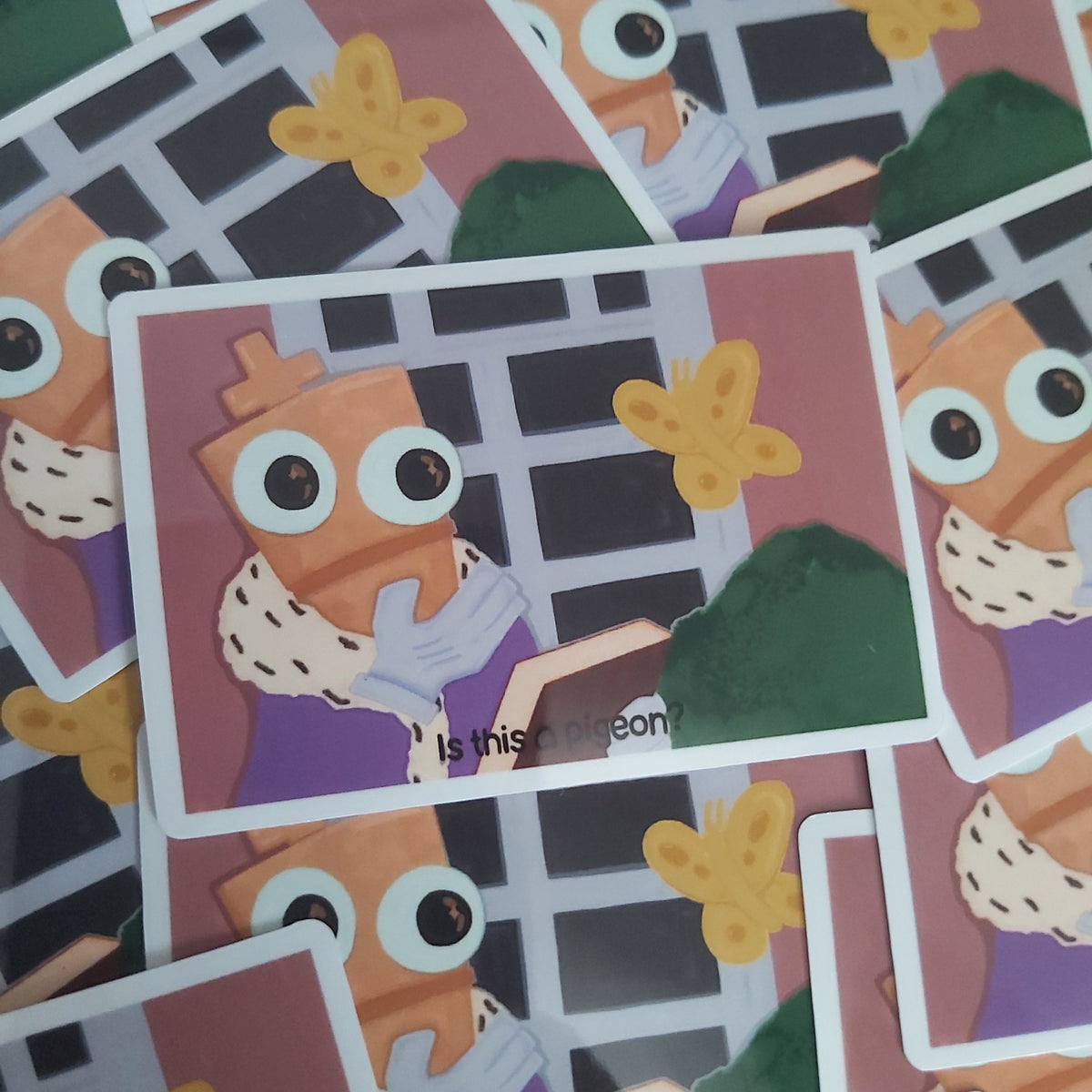 A pile of illustrated stickers featuring a cartoon chess piece character with large eyes, a purple outfit, and yellow butterfly-like shapes on a dark window background.