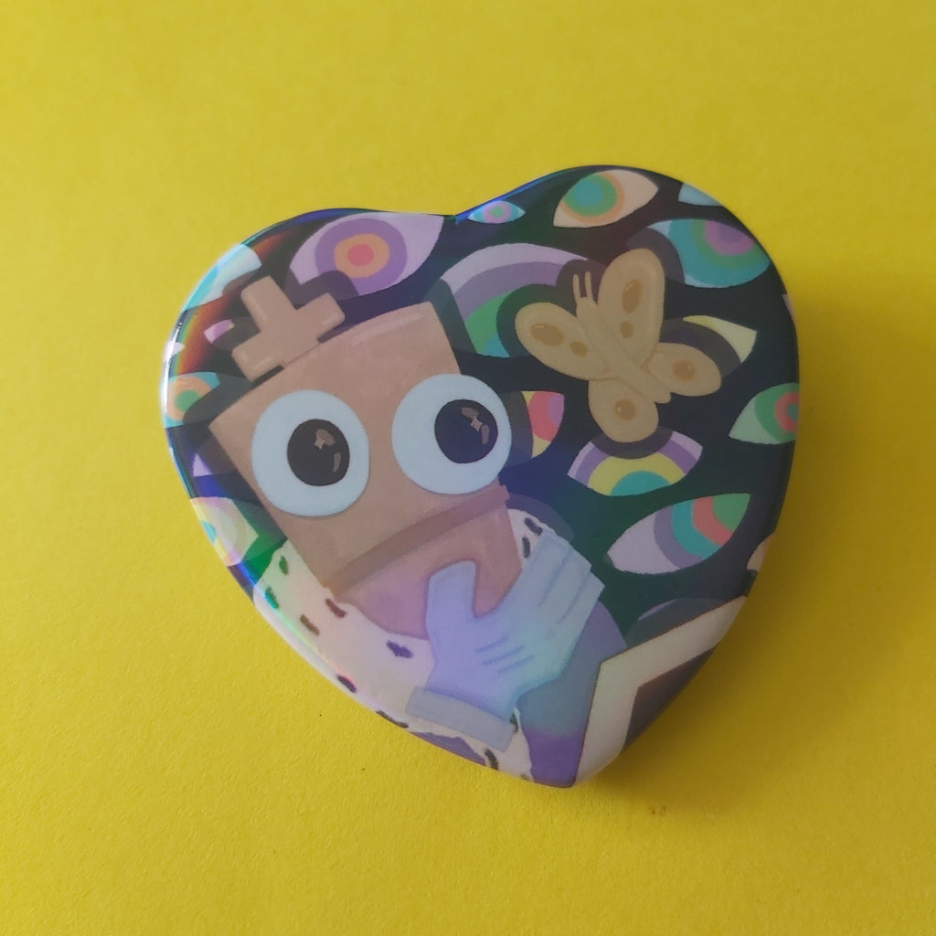 A heart-shaped pinback button featuring a colorful cartoon illustration of a character with large eyes and a butterfly, set against a solid yellow background.