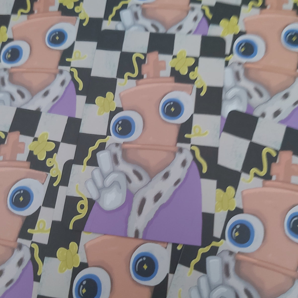 A close-up of a repeating illustrated pattern featuring cartoon robot faces with large blue eyes, peach bodies, white gloves, purple clothing, yellow flowers, and a black-and-white checkerboard background.