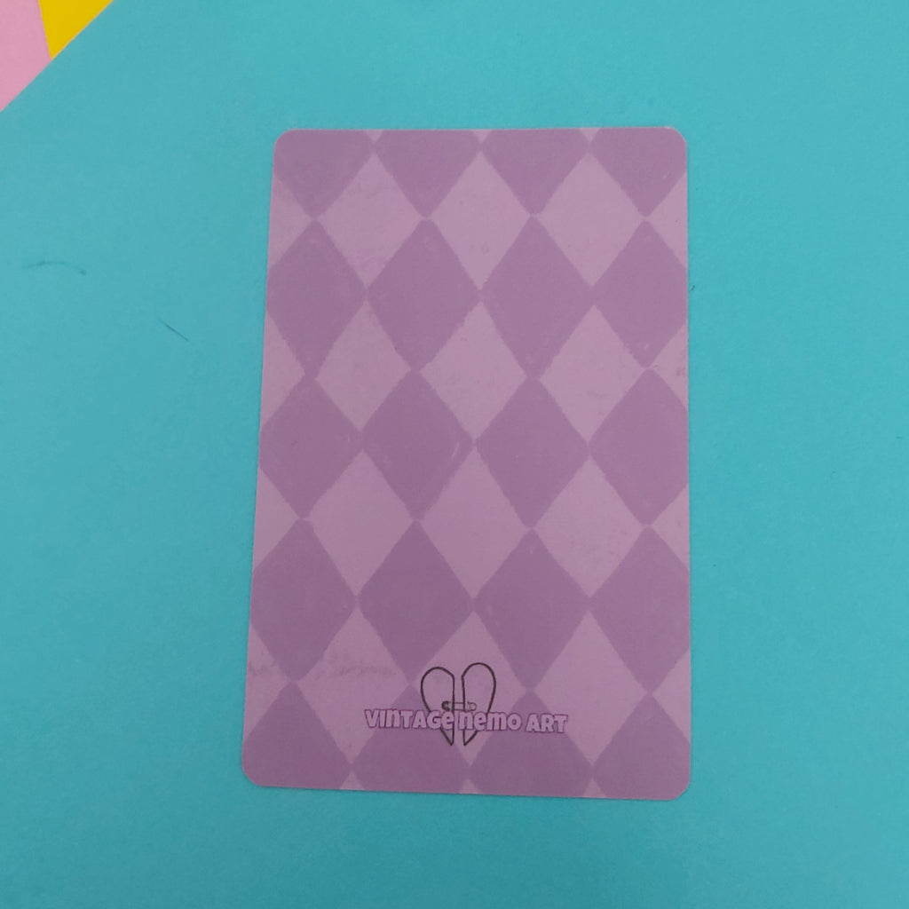 A lavender purple card with a diamond pattern and the text 'VINTAGE NEMO ART' at the bottom, placed on a bright turquoise background.