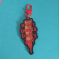 A red and black acrylic keychain charm with the gothic text 'what would buffy do?' printed on it, attached to a red carabiner clip, set against a bright blue background.