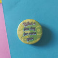 A round pinback button badge featuring a yellow-green patterned background with the text 'What a fine day for some yuri' in white lettering, set against a bright blue background.