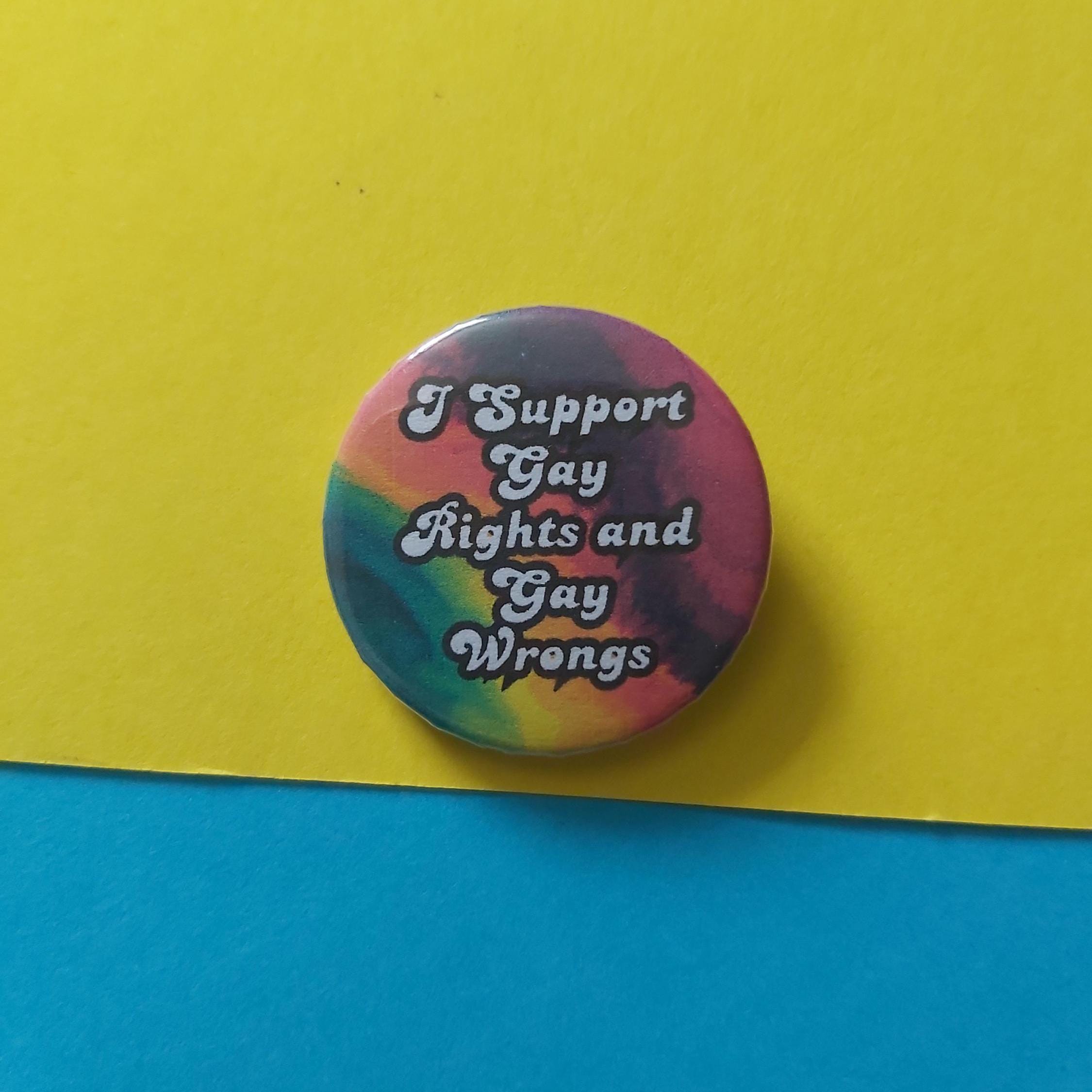 A round pinback button with a colourful tie-dye pattern and the text 'I Support Gay Rights and Gay Wrons' in white lettering, placed on a yellow and blue background.