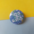 A round pin badge featuring a blue and green Earth design with the text 'SAVE the PLANET' in white and green, placed on a split yellow and light blue background.