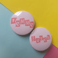 Two round pinback buttons with pink lettering on a pastel background. One button reads 'Femme' and the other reads 'Butch' in pink blocks.