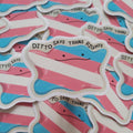 A close-up of multiple die-cut stickers featuring the transgender pride flag with the text 'DITTO SAYS TRANS RIGHTS' and a simple face, arranged overlapping on a white background.