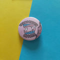 A round pinback button badge featuring a graphic of vampire teeth with blue accents and the text 'TRANS RIGHTS OR BITCHES' in black gothic lettering, set against a diagonally split yellow and blue background.