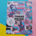 An art print featuring a colourful collage with the words 'TRANS PRIDE' in large black letters, surrounded by pink, blue, purple, and black text and graphics related to transgender rights. The print is photographed on a split pastel background with cyan on the left and pink on the right.