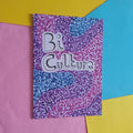 A rectangular product with a purple, pink, and blue dotted patterned cover featuring the text 'Bi Culture' in white with black outlines, displayed on a colourful background of pink, yellow, and blue paper.