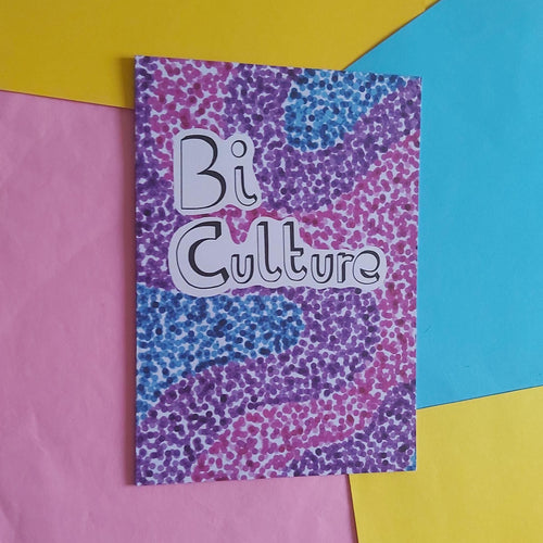 A rectangular product with a purple, pink, and blue dotted patterned cover featuring the text 'Bi Culture' in white with black outlines, displayed on a colourful background of pink, yellow, and blue paper.