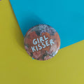 A round pinback button featuring a floral design with the text 'GIRL KISSER' in white lettering, placed on a split yellow and blue background.