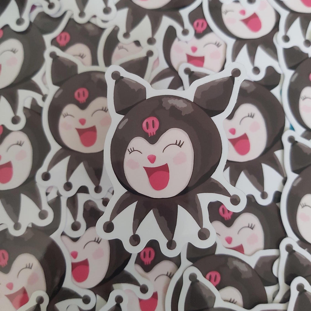 A close-up pile of cartoon stickers featuring a nlack and white character with pink accents, shown in multiple overlapping views.