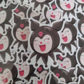 A close-up pile of cartoon stickers featuring a nlack and white character with pink accents, shown in multiple overlapping views.