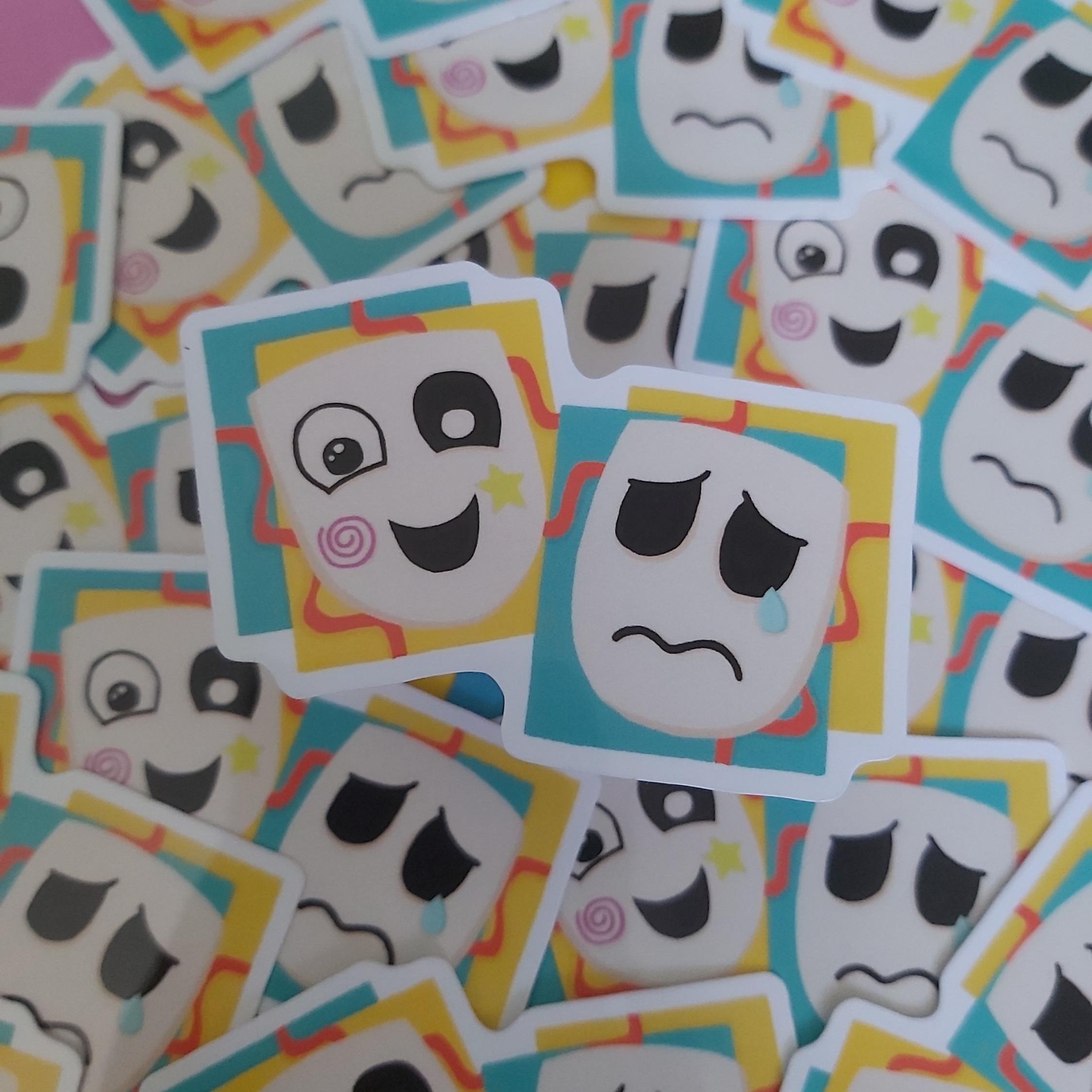 A pile of small stickers featuring cartoon mask faces in different expressions, including sad, happy, and confused looks, with turquoise, yellow, and pink border accents.