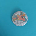 A round pinback button badge featuring a cartoon character on a white grid background.