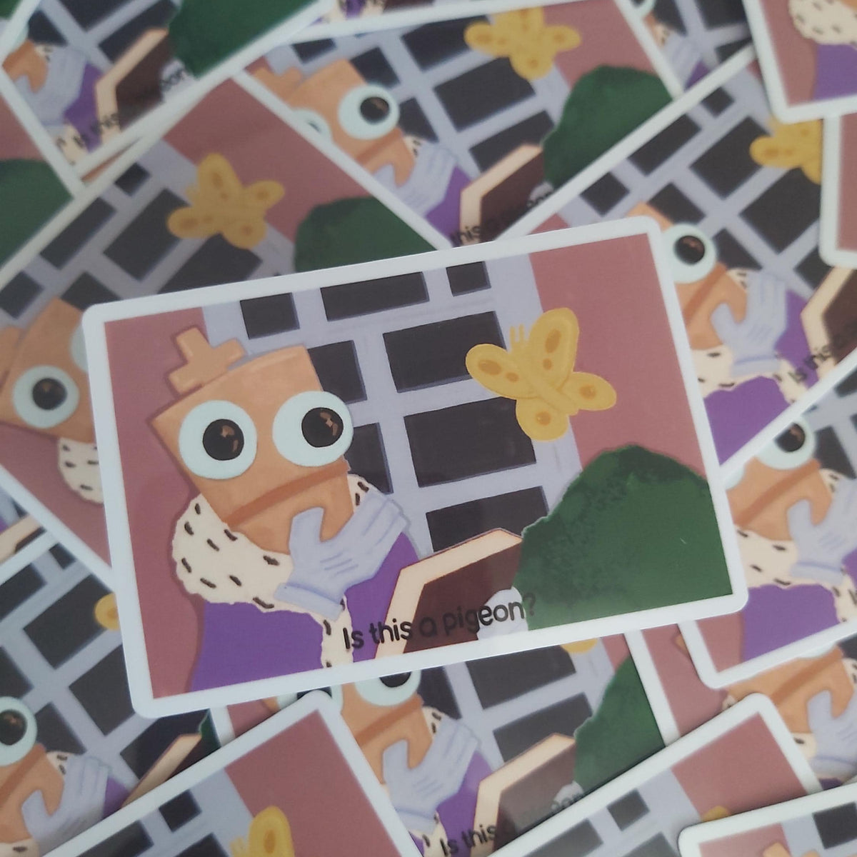 A close-up of a printed sticker featuring a cartoon chess piece wearing purple clothing, surrounded by scattered matching stickers with similar illustrated scenes.